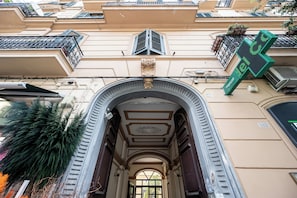 An arched entrance with a decorative ceiling, a green digital sign, and a building facade with balconies and a satellite dish. - Casalina 2 - One Bedroom Apartment, Sleeps 4 (Napoli)
