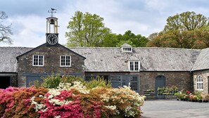 A building with a clock tower, multiple windows, and a garage door.