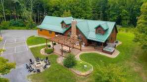 A lodge with a covered patio, outdoor seating, and a hot tub.