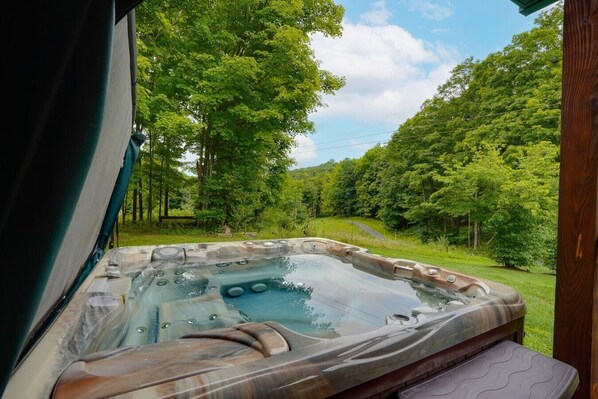 A hot tub with a view of a forested area.