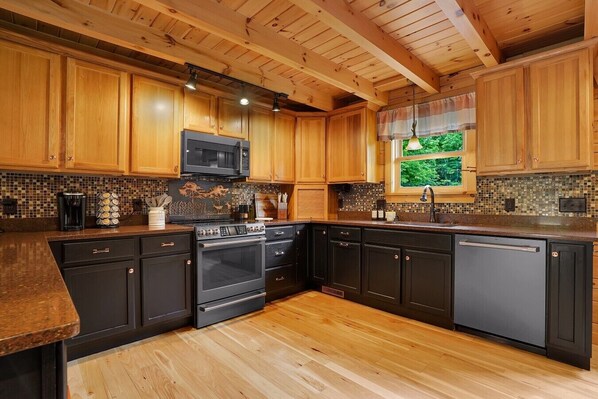 A kitchen with wooden cabinets, a microwave, a stove, and a dishwasher.