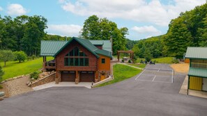 A lodge with a large driveway, a covered outdoor seating area, and a parking lot. - Triple Trac Lodge, upscale retreat in the countryside with 7 Bedrooms, hot tub, game room, and so much more. Plenty of fun for everyone! (East Waterford)