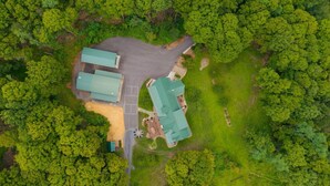An aerial view of a property with multiple buildings, a parking area, and surrounding greenery. - Triple Trac Lodge, upscale retreat in the countryside with 7 Bedrooms, hot tub, game room, and so much more. Plenty of fun for everyone! (East Waterford)