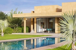 A modern house with a swimming pool, a covered patio, and a dining area with a view of the pool. - Villa Tallaght - Six Bedroom Villa, Sleeps 12 (Marrakesh)