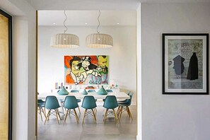 A dining area with a white table, teal chairs, and hanging wicker lamps. - Villa Tallaght - Six Bedroom Villa, Sleeps 12 (Marrakesh)