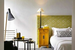 A hotel room with a bed, a bedside table with a lamp, a small round table with a lamp, and a cabinet with a patterned wallpaper. - Villa Tallaght - Six Bedroom Villa, Sleeps 12 (Marrakesh)