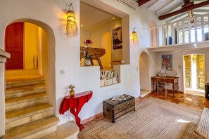 A spacious living area with a staircase, a red console table, a wooden chest, and a bookshelf. - Maison Huguette - Five Bedroom Villa, Sleeps 10 (Paradou)