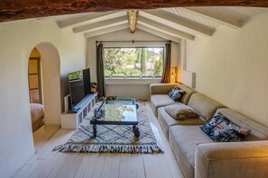 Een gezellige woonkamer met een bank, een salontafel en een televisie.