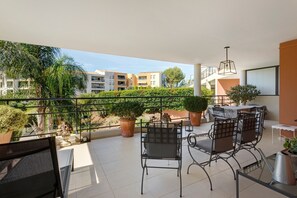 A balcony with outdoor seating, potted plants, and a view of neighboring buildings. - “Saint Raphael De Luxe” Apartment with Shared Pool and Private Terrace (Saint-Raphaël)