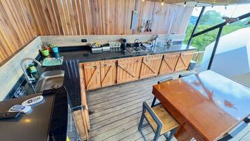 Una cocina con armarios de madera, una encimera y un comedor con una mesa y sillas.