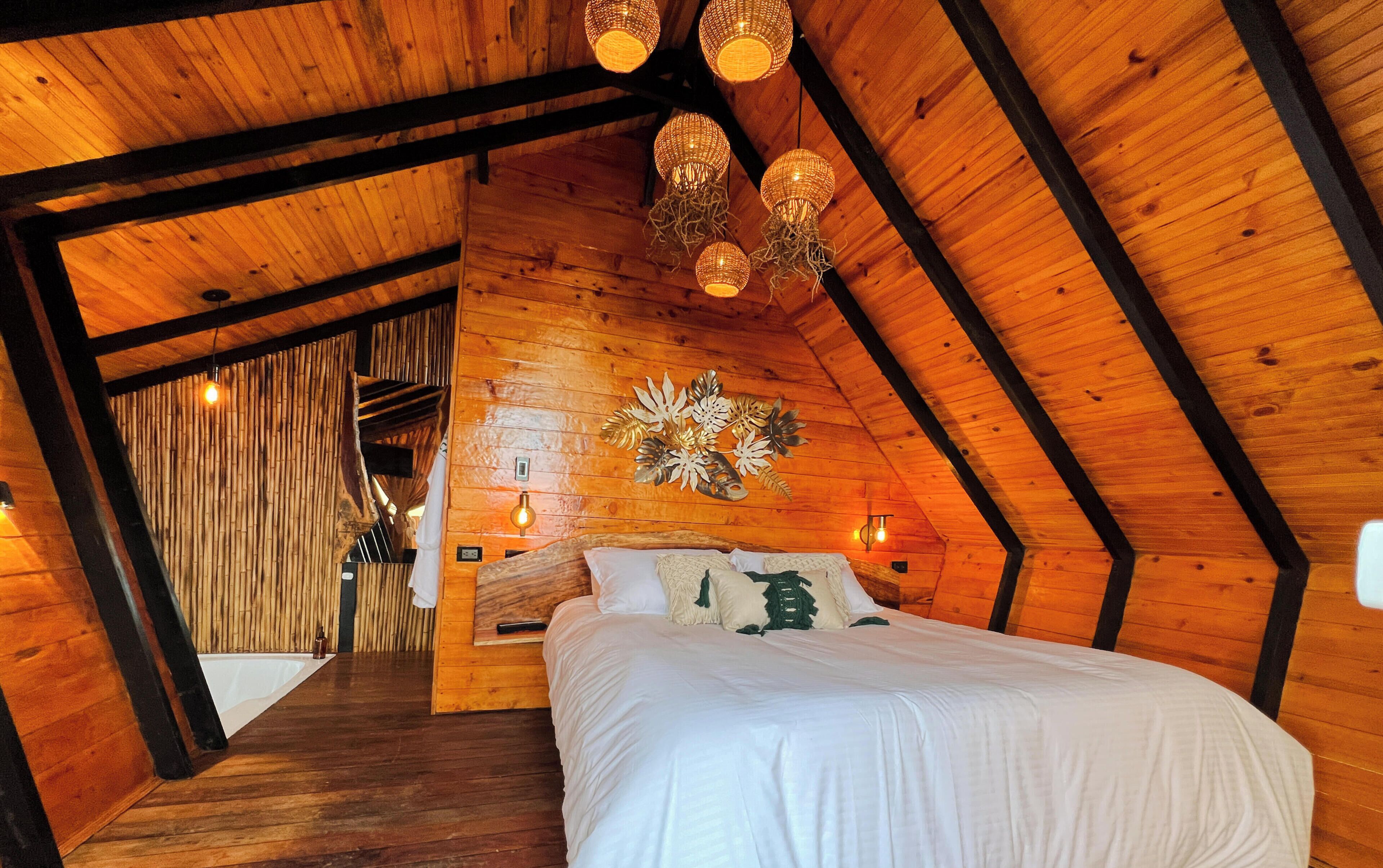 A wooden interior with a bed, a wall-mounted light fixture, and a bamboo wall.