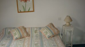 A bed with striped bedding and two pillows, a bedside table with a lamp, and a framed picture on the wall. - Holiday Home 'Gite Des Carcis' with Mountain View, Private Terrace and Wi-Fi (Ganac)