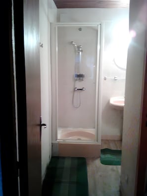 Ein Badezimmer mit Dusche, Toilette und Waschbecken.