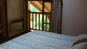 A bedroom with a bed, a window, and a view of greenery outside. - Holiday Home 'Gite Des Carcis' with Mountain View, Private Terrace and Wi-Fi (Ganac)