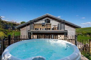 A two-story building with a hot tub in front.