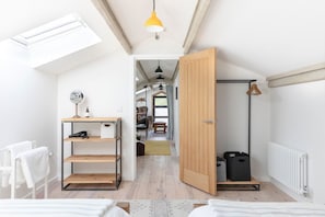 A compact room with a skylight, a wooden door, a radiator, and a hanging light fixture.