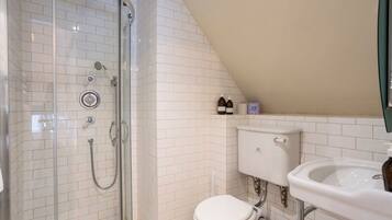Ein Badezimmer mit einer Duschkabine, einer weißen Toilette und einem Waschbecken.