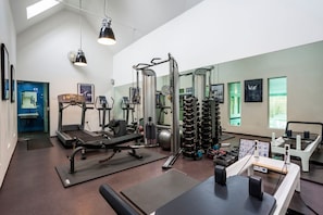 A gym with exercise equipment, a treadmill, and a weight rack.