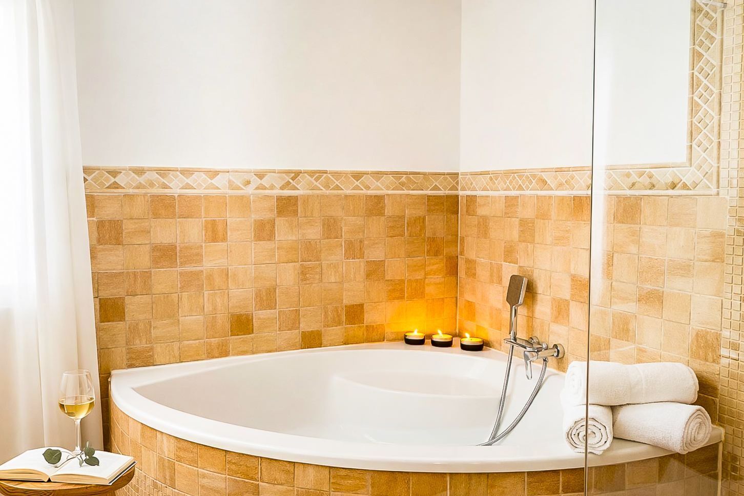 A bathroom with a bathtub, a glass shower enclosure, and a towel rack.