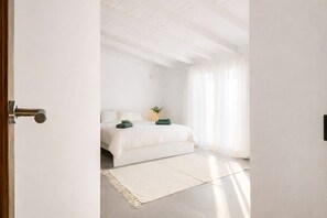 A hotel room with a bed, a small table, and a window with curtains. - Villa Alora Lux - Two Bedroom Villa, Sleeps 6 (Álora)