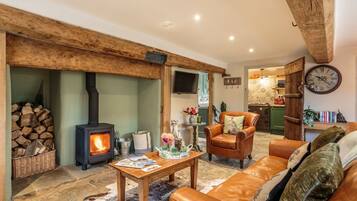 A cozy living room with a fireplace, leather sofa, and a dining area.