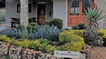 A stone pillar, a wooden door, and a sign for Crimson Cottage.
