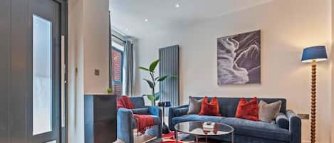 A modern living room with a sofa set, a coffee table, and a floor lamp.