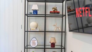 A modern bookshelf with various decorative items including books, a lamp, and a sculpture. - New Central Home | Groups, Contractor & Families (Reading)