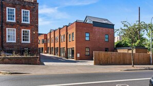 A row of modern brick buildings with large windows and a clear sky. - Modern Reading House|Contractor & Family Friendly (Reading)