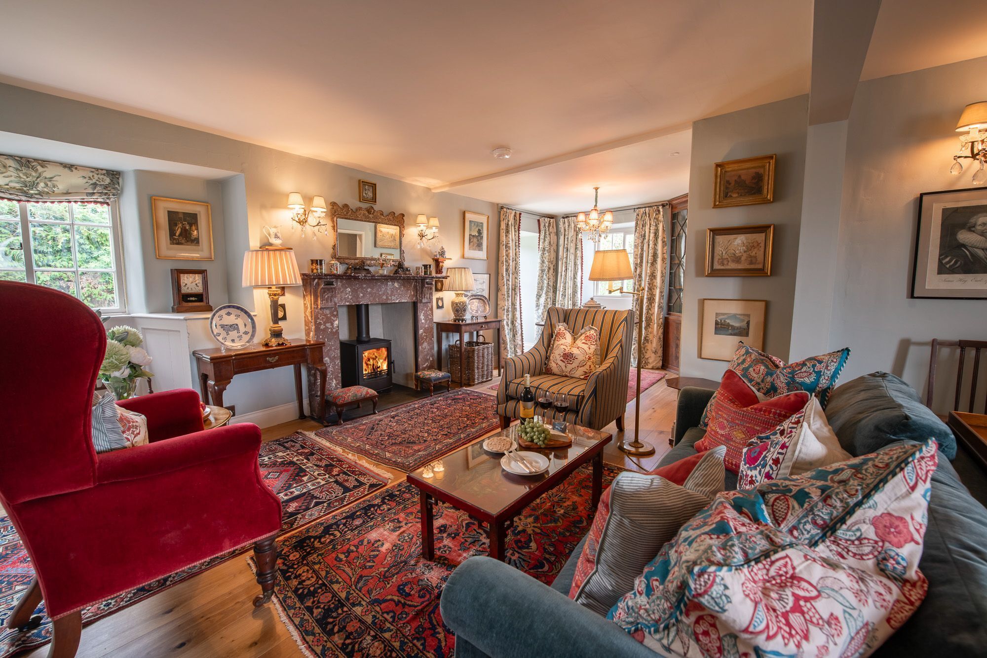 Een knusse woonkamer met een open haard, zachte zitplaatsen en decoratieve accessoires.
