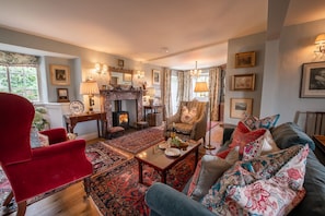 A cozy living room with a fireplace, comfortable seating, and decorative items.