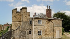 A stone building with a tower, a door, and windows.