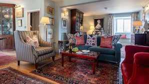 A living room with a sofa, armchair, and a coffee table with decorative items.