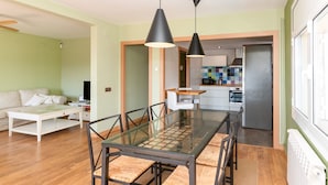 A modern kitchen with a microwave, oven, and a tiled backsplash. - Apartment Limoncello (Sant Pere de Ribes)
