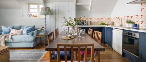 Un coin repas avec une table en bois, des chaises et un vase de fleurs.