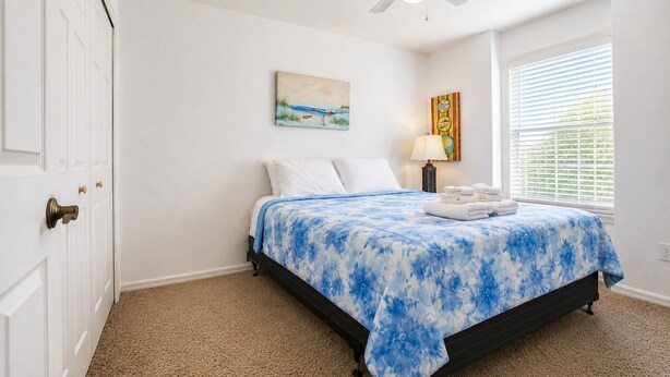 A bedroom with a bed, a ceiling fan, a window with blinds, and a door. - LUX Mins to St George St - Anastasia Beach - Flagler Hospital - Sunrise (St. Augustine)