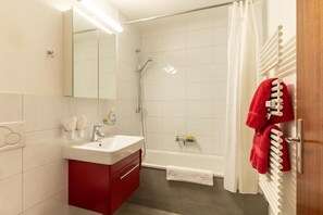 A bathroom with a shower, a sink, and a mirror. - Victoria B Studio - InspiringPlaces  (Zermatt)