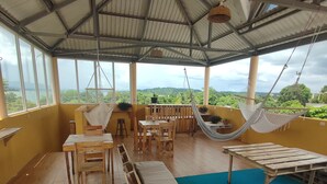 A covered outdoor area with a pool, wooden furniture, and a hammock. - La Casa Colorada (San Benito)