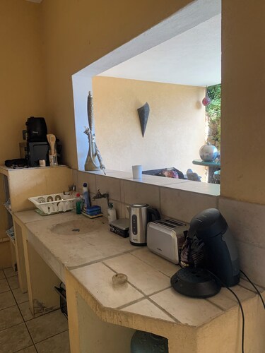 Room for rent with shower and summer kitchen in a lush, green setting with a pool