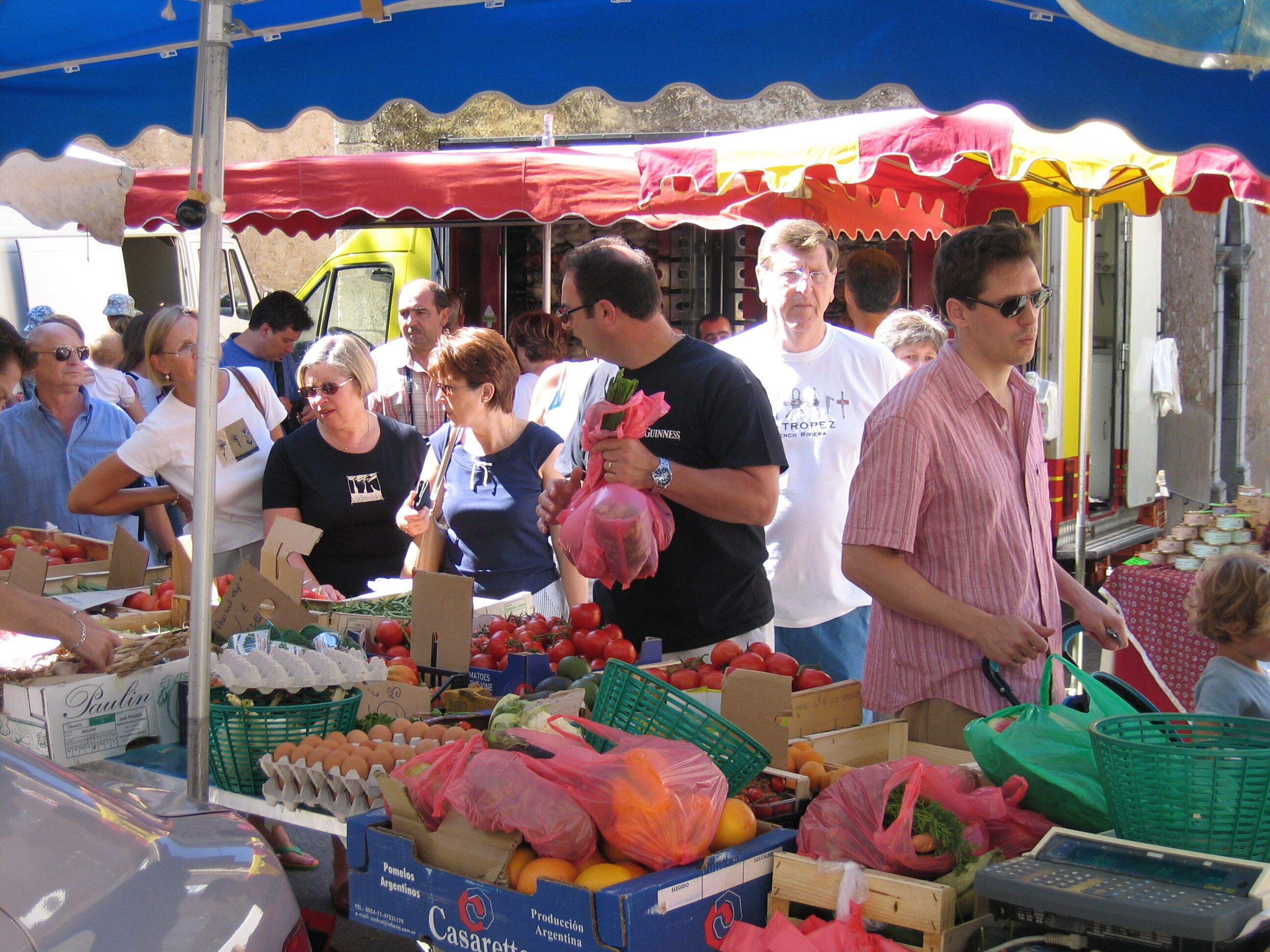 A market stall with various produce and packaged goods.