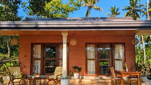 A brick house with a covered porch, large windows, and outdoor furniture. - Private Pool Villa (Tangalle)