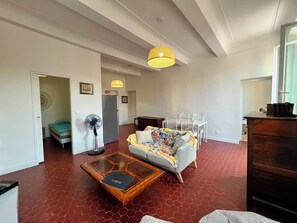 Ein Wohnzimmer mit einer Couch, einem Couchtisch und einem Essbereich mit Stühlen.