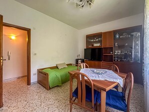A compact room with a bed, a small table, a chair, a television, and a cabinet with glass doors. - Apartament in Minori (Minori)