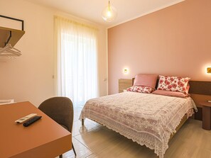 Ein Schlafzimmer mit einem Bett, einem Schreibtisch und einem Stuhl.