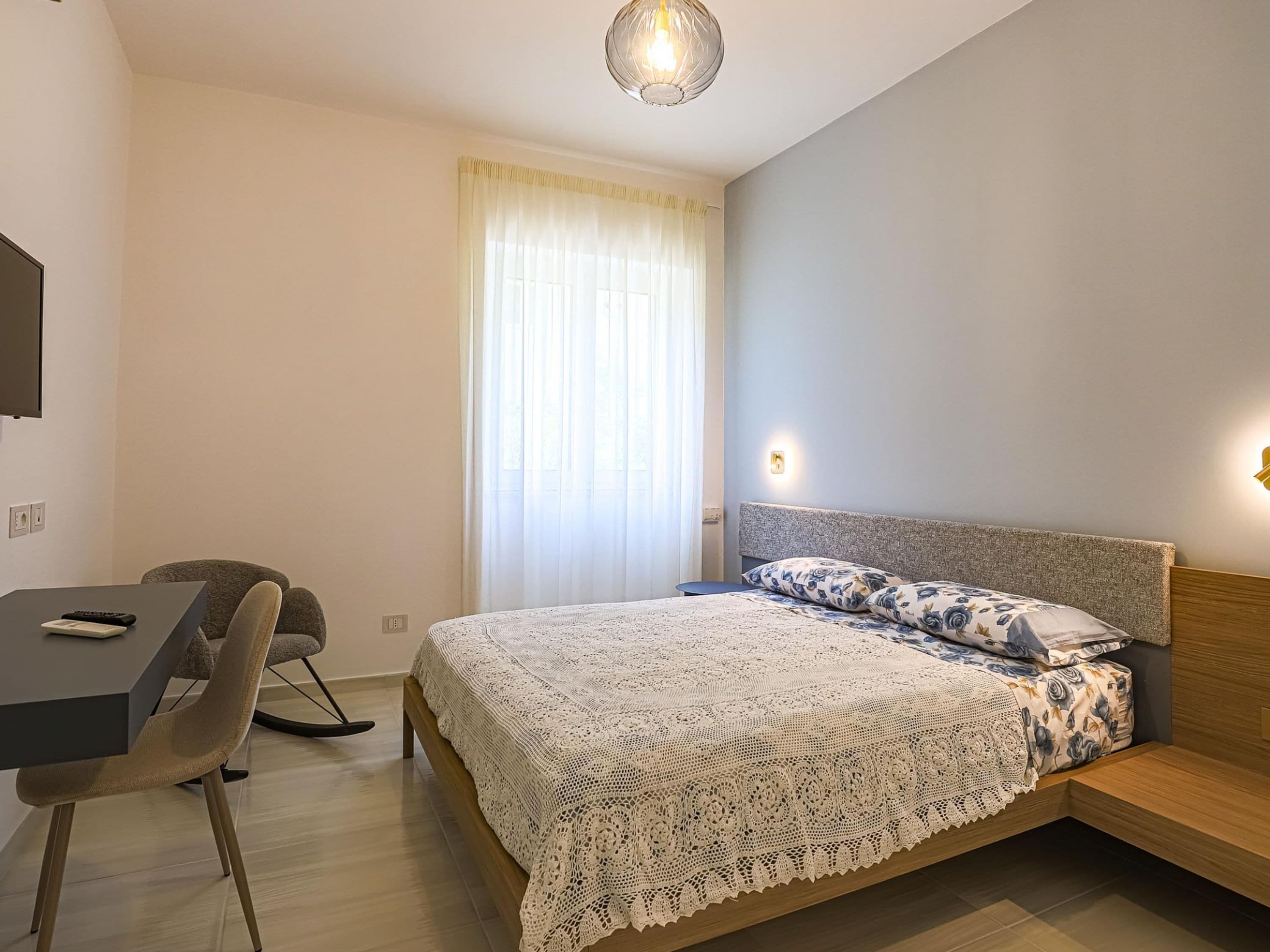 Un dormitorio con una cama, un escritorio y una silla.