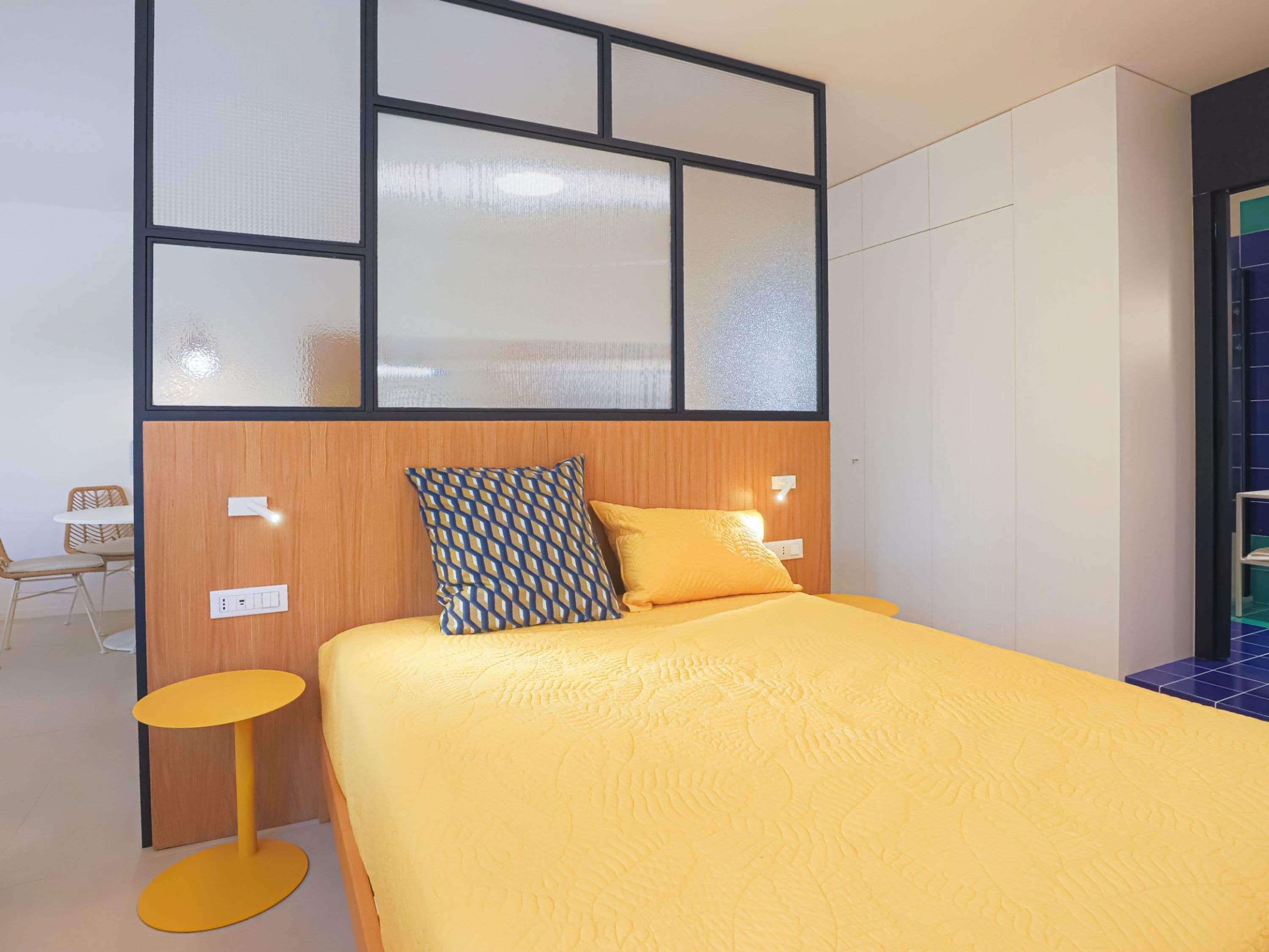 Una habitación de hotel con una cama, una mesita redonda y una silla.