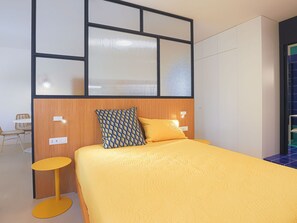 Una habitación de hotel con una cama, una mesita redonda y una silla.