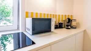 A kitchen with a microwave, coffee maker, and a kettle on the counter. - Blue Elina - Amami Viaggi Collection (Salerno)