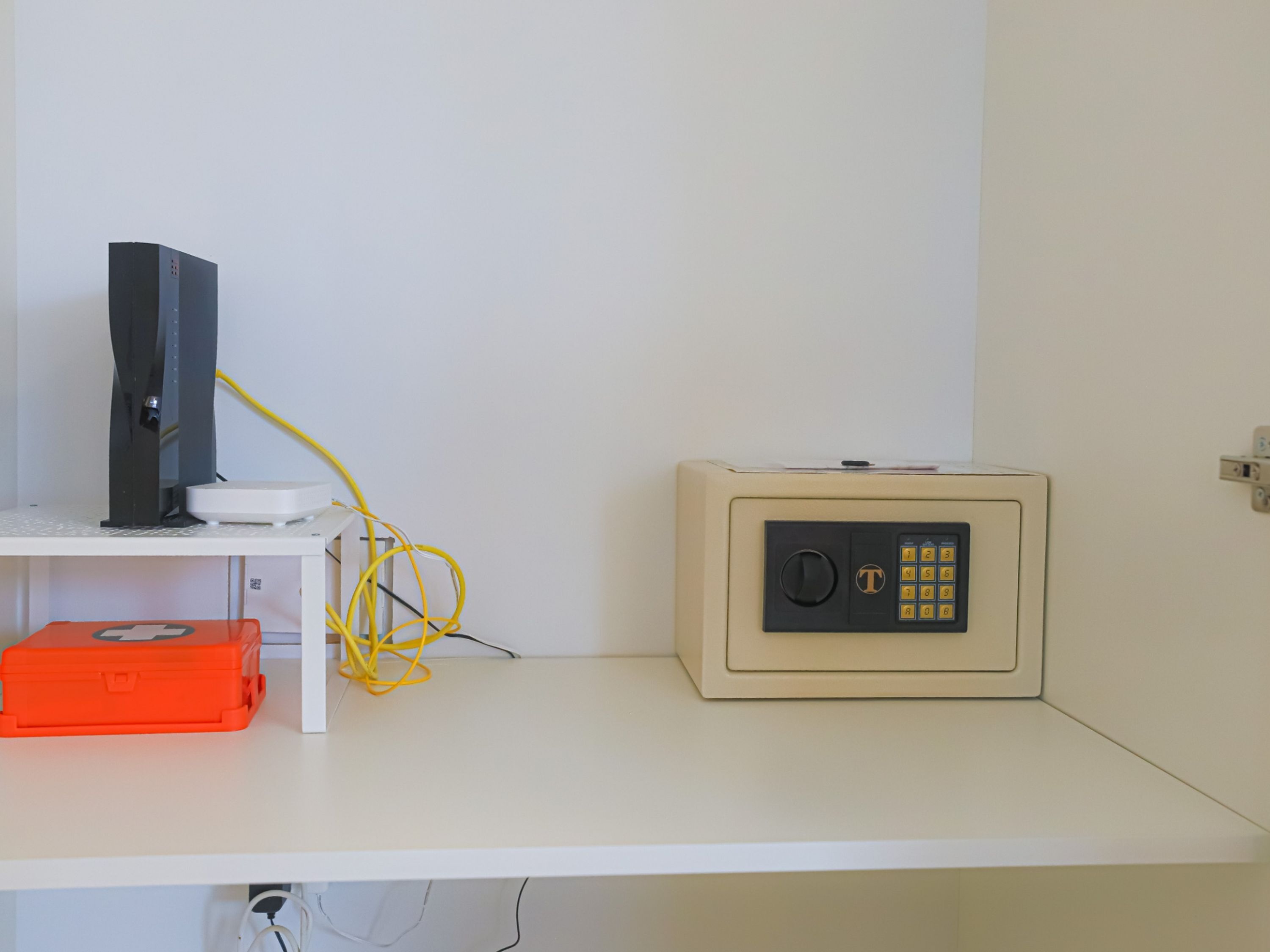 Una habitación con escritorio, caja fuerte y ordenador.
