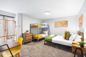 A compact room with bunk beds, a desk, a chair, a dresser, and a map on the wall. - Hove Hideout By My Getaways (Hove)